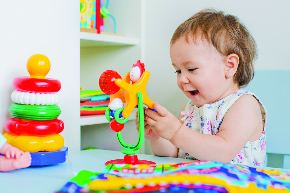Baby Girl Playing With Educational Toy In Nursery